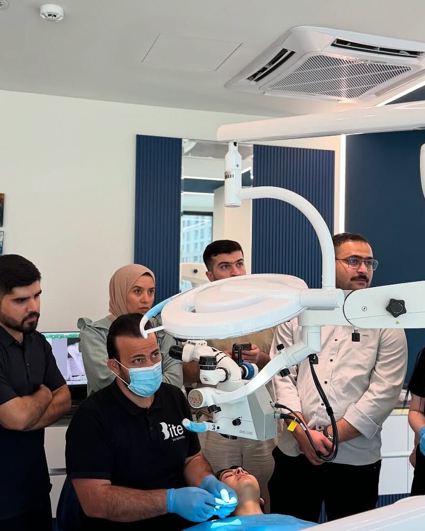 Course participants observing Dr. Jegr Koyi treating a real patient under the microscope